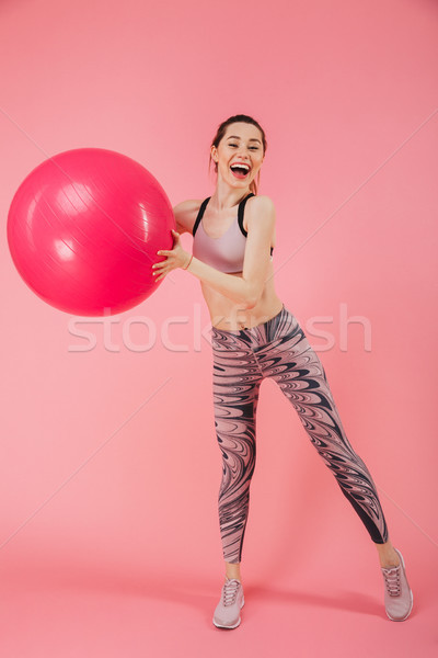 Vertical image of Playful sportswoman doing exercise with fitness ball Stock photo © deandrobot