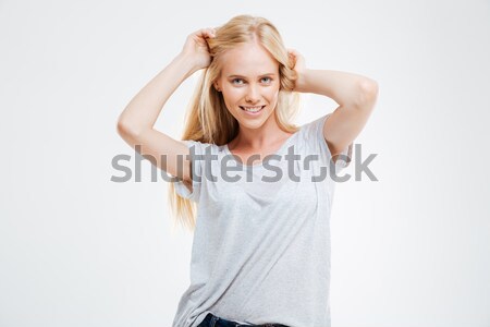 Portrait of a laughing woman closing her eyes with hand over gray background Stock photo © deandrobot