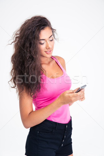 Genç kız yazarak sms telefon yalıtılmış beyaz Stok fotoğraf © deandrobot
