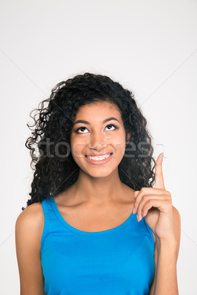 Afro american woman pointing finger up at copyspac Stock photo © deandrobot