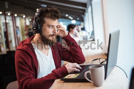 Concentrat masculin setul cu cască laptop frumos barba Imagine de stoc © deandrobot