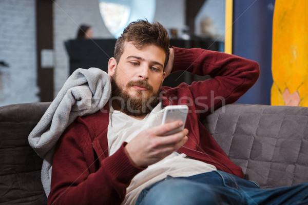Entspannt junger Mann Sofa Mobiltelefon jungen gut aussehend Stock foto © deandrobot