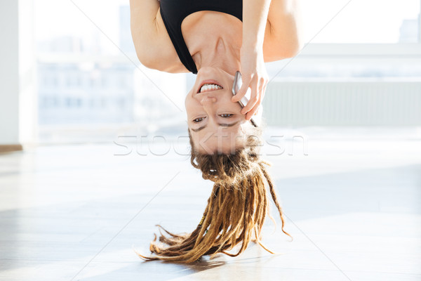 Upside down view of happy woman talking on mobile phone Stock photo © deandrobot
