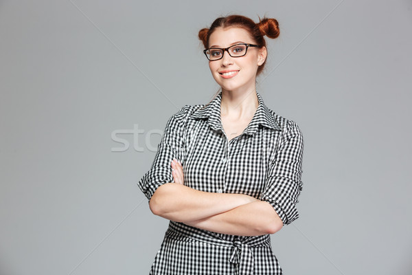 Derűs csinos fiatal nő szemüveg áll keresztbe tett kar Stock fotó © deandrobot