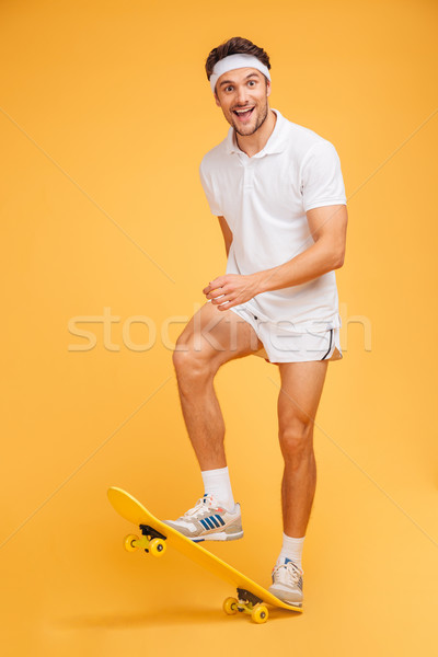 Happy young sports man skateboarding Stock photo © deandrobot