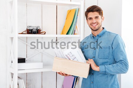 Mosolyog fiatalember áll polc mappák iratok Stock fotó © deandrobot