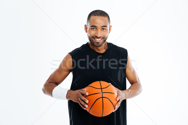 Happy african basketball player standing with ball Stock photo © deandrobot