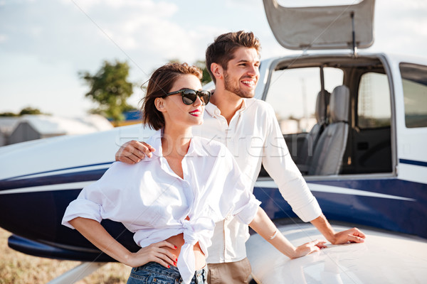 Beautiful young couple standing near small private aircraft Stock photo © deandrobot