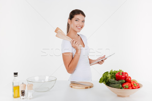 Cheerful woman cooking with vegetables Stock photo © deandrobot
