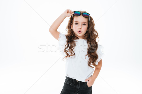 Maravilhado little girl óculos de sol em pé posando Foto stock © deandrobot
