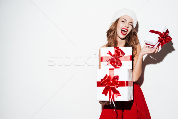 Excited woman in red santa claus outfit holding stack presents Stock photo © deandrobot