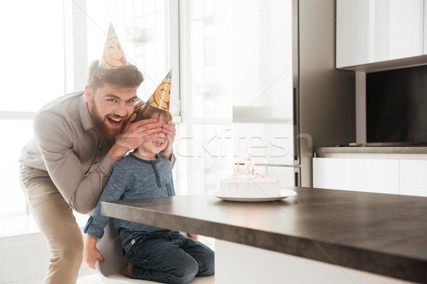 Joyful father covering birthday son's eyes Stock photo © deandrobot