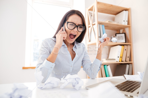 Confused businesswoman screaming while talking by phone Stock photo © deandrobot