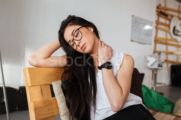 Tired exhausted woman in glasses sitting and relaxing Stock photo © deandrobot