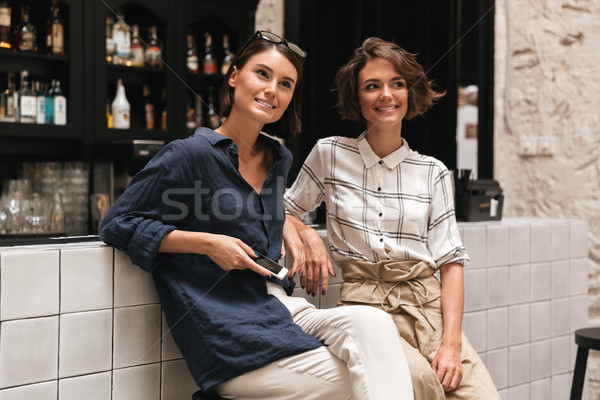 Two pretty friends sitting neat the bar Stock photo © deandrobot