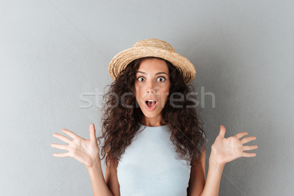 Sorprendido mujer sombrero mirando cámara pelo rizado Foto stock © deandrobot