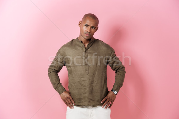 Serious african man holding arms on hips Stock photo © deandrobot
