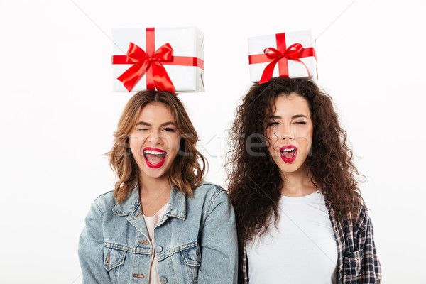 Image of Two happy girls holding gifts on their heads Stock photo © deandrobot