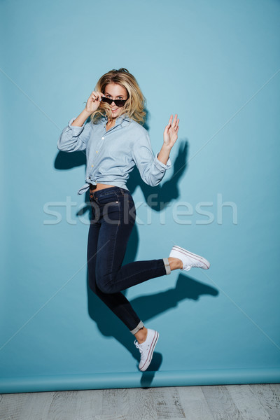 Full length image of Smiling woman in shirt and sunglasses Stock photo © deandrobot