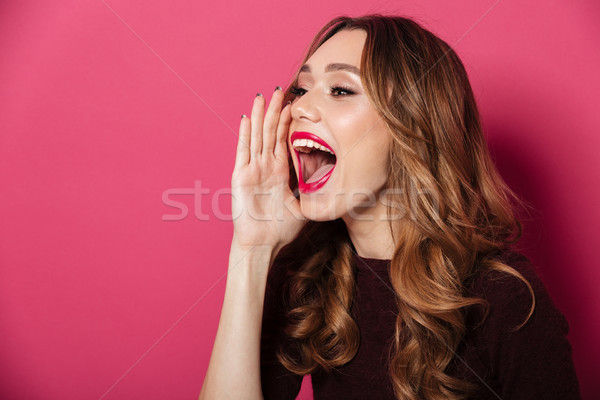 Beautiful woman standing isolated over pink Stock photo © deandrobot