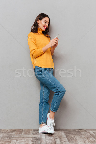 Full length image of Pleased brunette woman in sweater Stock photo © deandrobot