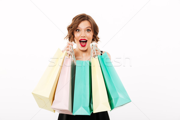 Porträt aufgeregt Mädchen schwarzes Kleid halten Einkaufstaschen Stock foto © deandrobot