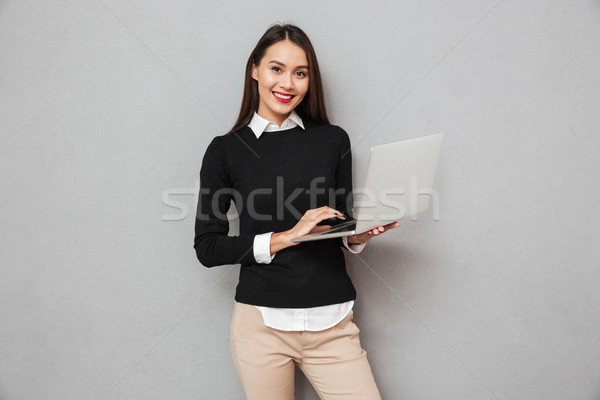 Glimlachend asian vrouw business kleding met behulp van laptop Stockfoto © deandrobot