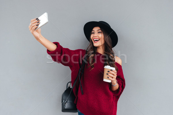 Portrait of a smiling young asian girl dressed in hat Stock photo © deandrobot