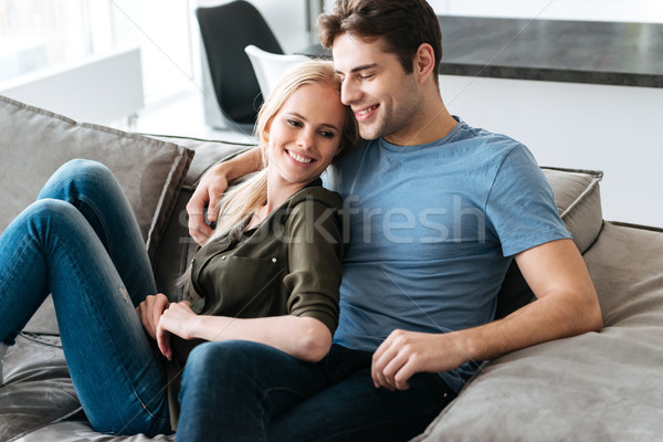 Young blonde lady looking camera while sitting with her man Stock photo © deandrobot