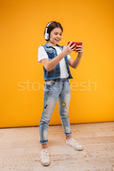 Portret gelukkig weinig schoolmeisje luisteren naar muziek Stockfoto © deandrobot