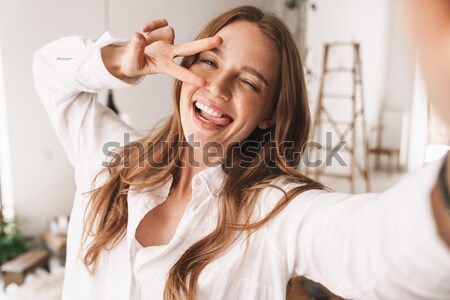 Happy beautiful woman talking on the phone at home Stock photo © deandrobot