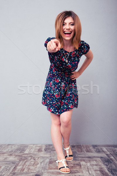 Laughing woman pointing finger at camera Stock photo © deandrobot