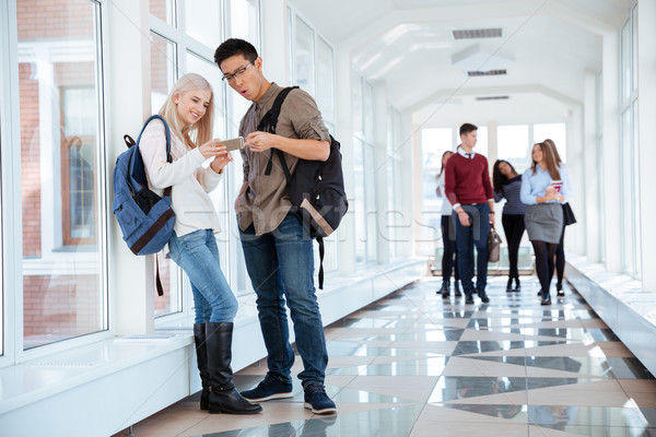 Studenten smartphone universiteit hal portret gelukkig Stockfoto © deandrobot