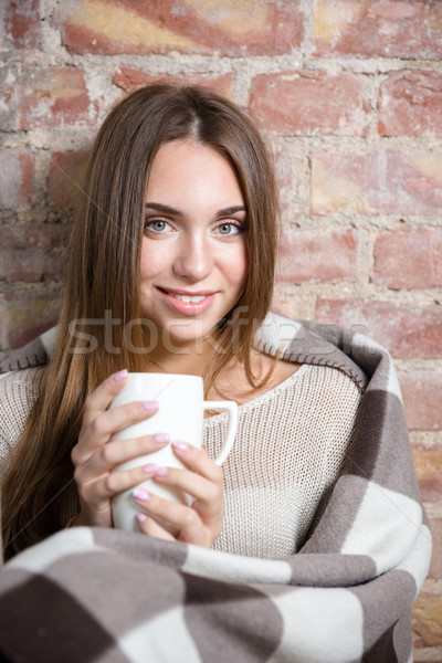 Smiling woman in warm plaid holding cup with hot coffee Stock photo © deandrobot