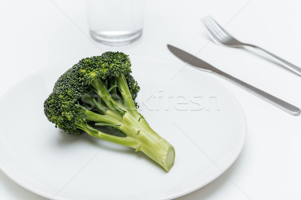 Glass of water, fork, knife and broccoli on the plate Stock photo © deandrobot