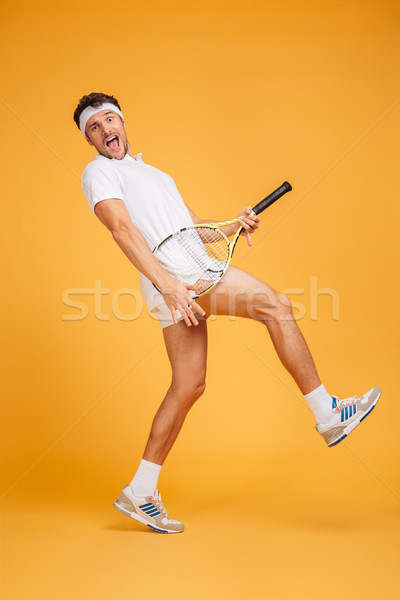 Funny playful young man tennis player having fun using racket Stock photo © deandrobot