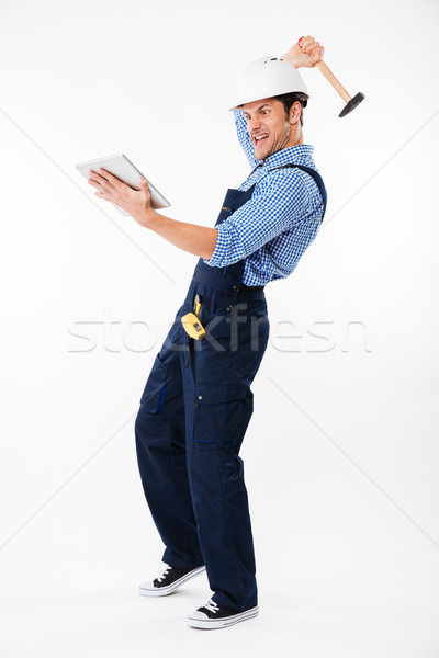Portrait of an angry builder trying to break pc tablet Stock photo © deandrobot