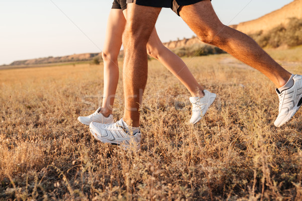 Cropped image of a young couple legs in sneakers running Stock photo © deandrobot