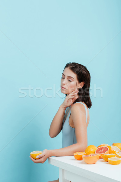 Tender woman with eyes closed standing and holding orange half Stock photo © deandrobot
