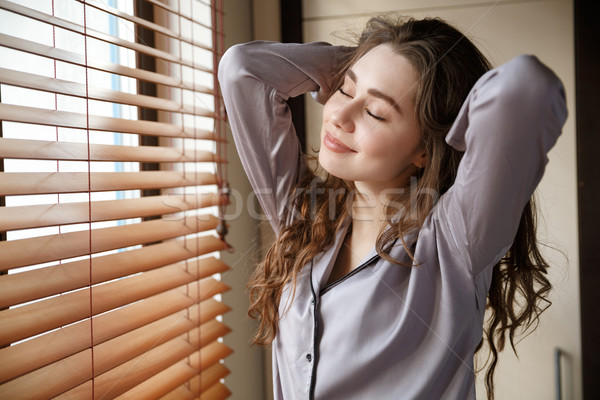 Pleased woman with closed eyes Stock photo © deandrobot
