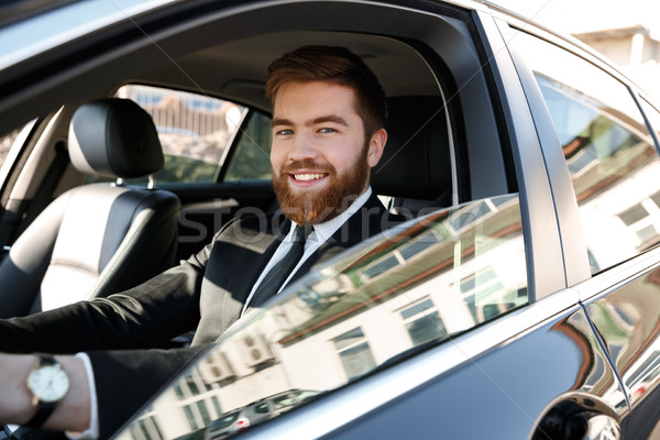 Widok z boku uśmiechnięty człowiek biznesu jazdy samochodu garnitur Zdjęcia stock © deandrobot