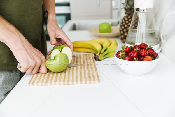Cropped image of man cooking. Stock photo © deandrobot