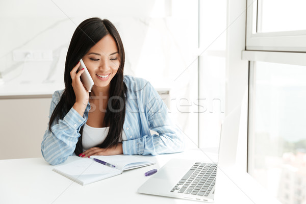 Smiling asian woman talking on mobile phone Stock photo © deandrobot