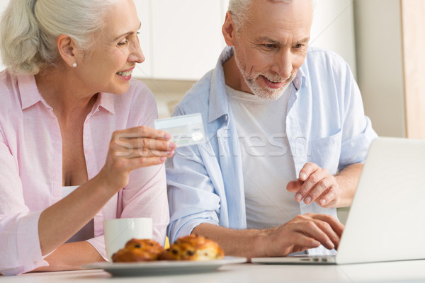 Stock photo: Happy mature loving couple family using laptop holding credit card