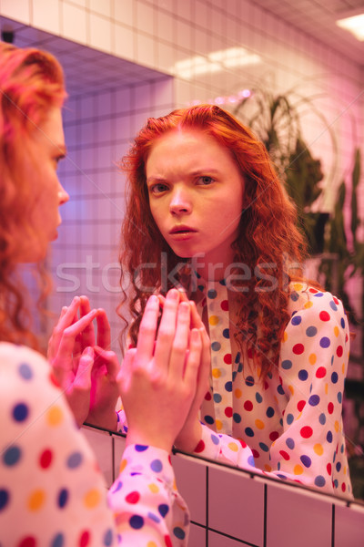 Redhead curly lady standing near mirror Stock photo © deandrobot