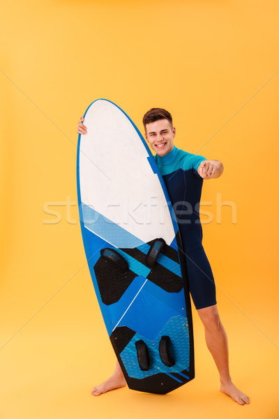 Full length portrait of confident smiling man in swimsuit pointi Stock photo © deandrobot
