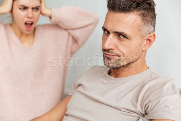 Close-up image of Confused man sitting on couch with girlfriend Stock photo © deandrobot