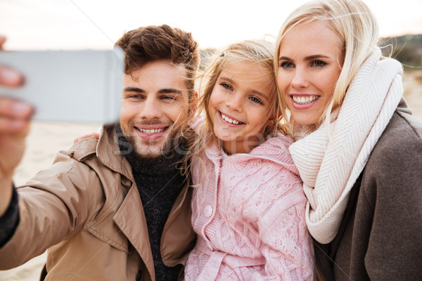 Portrait of a cheery family with a little daughter Stock photo © deandrobot