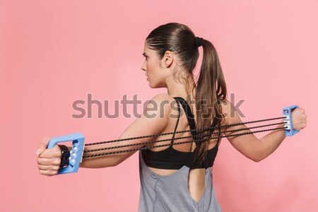 Vertical image of Concentrated curly brunette fitness woman Stock photo © deandrobot