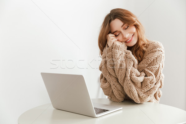 Image of relaxed woman 20s wearing knitted sweater sitting at ta Stock photo © deandrobot